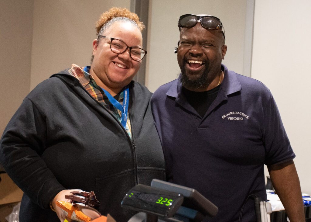 A smiling customer stands next to Willie Patrick in The Market.